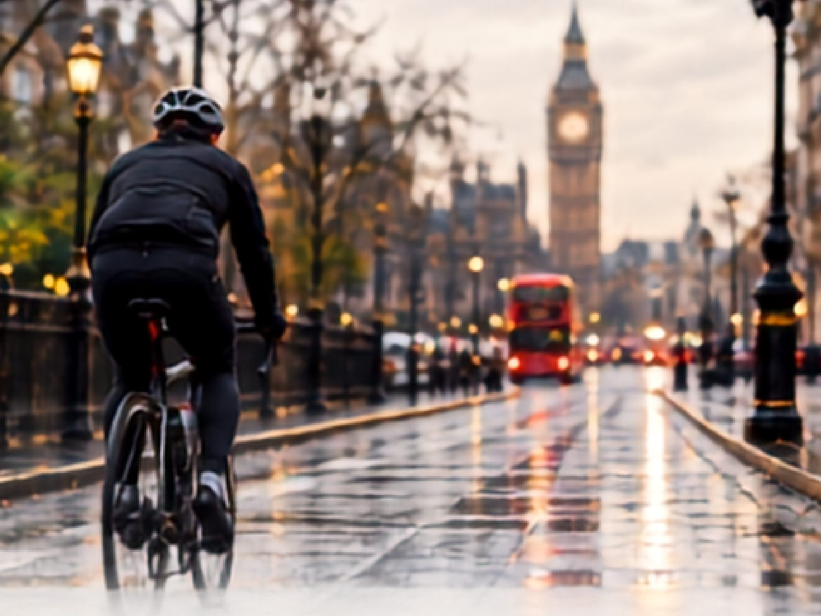 A cyclist riding a wet London street toward Big Ben at dusk.